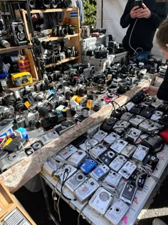 two men are looking at cameras on a table