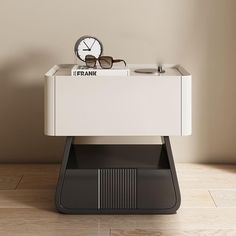 a white table with a clock and some glasses on it's top, in front of a beige wall