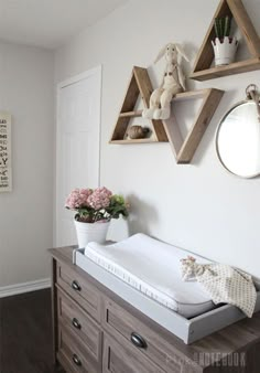 a baby's crib in the corner of a room with hanging decorations on the wall