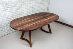 a wooden table sitting on top of a white tiled floor next to a brick wall