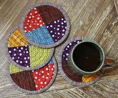 three colorful coasters with polka dots on them and a cup of coffee in the middle