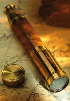 a close up of a magnifying glass on top of a map with a compass