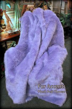 a purple fur blanket sitting on top of a chair