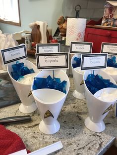 there are several cups with toothbrushes in them sitting on the counter top next to each other