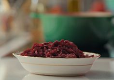 a white bowl filled with red food on top of a counter