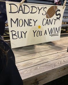 a sign that says daddy's money can't buy you a win on a bench