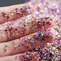 someone is holding their hand full of colorful sprinkles