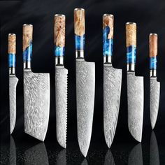 five knives with different designs on them are lined up in a row against a black background