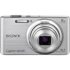 a silver digital camera sitting on top of a white surface