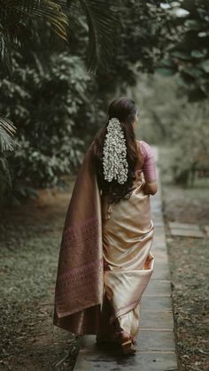 a woman in a sari walking down a path