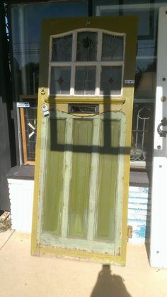 an old green door sitting in front of a store