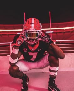 a football player kneeling down with his hands on his knees in front of the camera