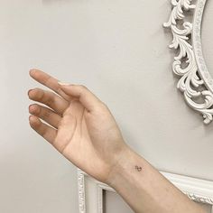 a person's hand with a small tattoo on the middle of their left arm