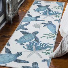 a blue and white rug with sea turtles on the floor next to a radiator