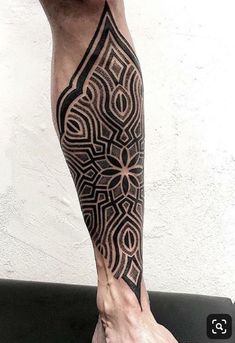 a man's leg with an intricate tattoo on it