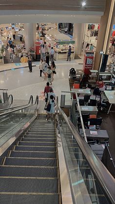 an escalator in a shopping mall with people walking up and down the stairs