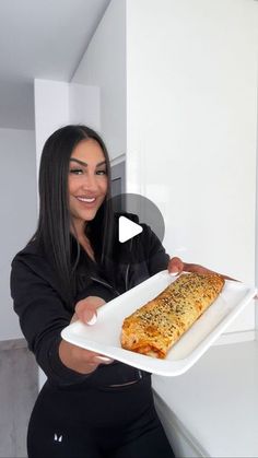 a woman holding a white plate with food on it