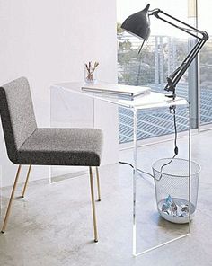 a desk with a chair and a lamp next to it in front of a window