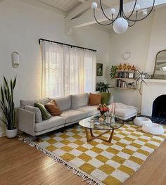 a living room filled with furniture and a fire place under a chandelier over a fireplace