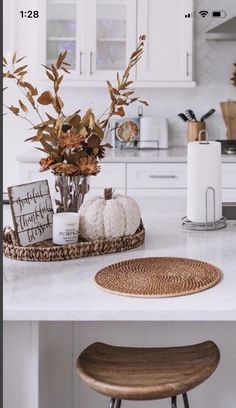 a kitchen counter with a basket on top of it next to a stool and potted plant