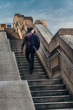 a man with a backpack walking up some stairs to the top of a flight of stairs