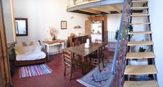 a living room filled with furniture and a spiral staircase leading up to the top floor