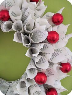 a wreath made out of books with red and white ornaments on it's front