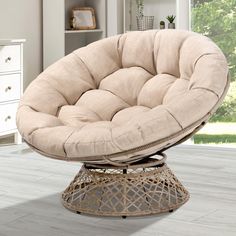 a round chair sitting on top of a wooden floor next to a dresser and window