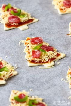 small pieces of pizza with toppings on a baking sheet, ready to go into the oven