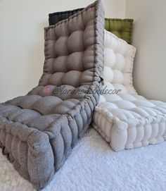 two large mattresses sitting on top of each other in a room with white walls