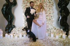 a man and woman standing next to a dog