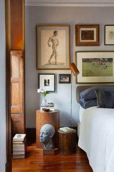 a bed room with a neatly made bed and pictures on the wall