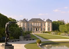 a statue in front of a large house