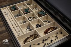 an open drawer filled with jewelry on top of a wooden floor