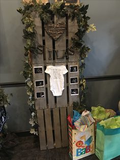 a baby's bodysuit is on display in front of some bags and presents