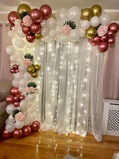 the balloon arch is decorated with pink, gold and white balloons for an elegant look