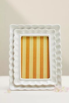 a white and yellow striped photo frame sitting on top of a table