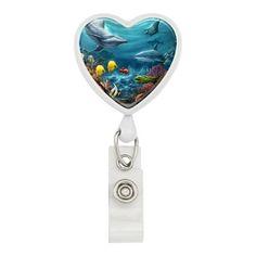 a heart shaped badge with dolphins and fish on it