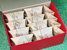 a red box filled with lots of brown paper bags and numbers on top of them