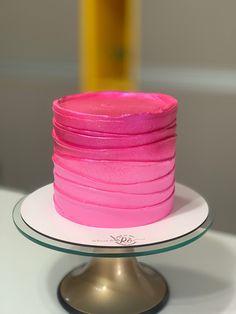 a pink cake sitting on top of a white plate