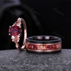 two wedding rings with red and white stones on them, one has a heart shaped stone in