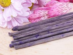 lavender sticks on a table with flowers in the background