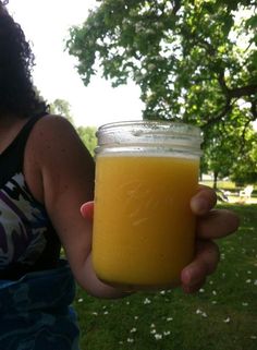 a person holding a jar of orange juice