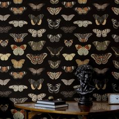 a table with a clock and wallpaper on it in front of a black background