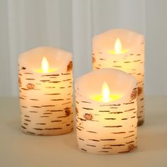 three lit candles sitting next to each other