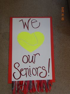 a sign that says we love our seniors on the floor next to a carpeted area