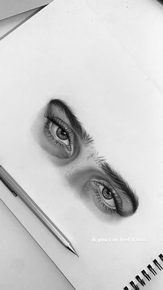 a pencil drawing of two eyes on top of a piece of paper