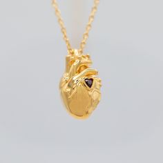 Our Ruby Anatomical Heart Necklace, with a heart shaped, ethically sourced ruby at its heart center, is perfect for anyone with a love for science, anatomy, and realism. The intricate details of the heart provide a unique accessory. Made with high-quality materials, this necklace is also a sparkling and stylish addition to any outfit.   14K gold vermeil (2.5 microns) over recycled solid sterling silver. 16x10 mm pendant. Ruby heart. 14 inch chain. 4 inch extender. Lobster clasp. Science Anatomy, Anatomical Heart Necklace, Heart Center, Ruby Heart, Anatomical Heart, Gold Heart Necklace, Accessories Unique, Intricate Details, A Heart