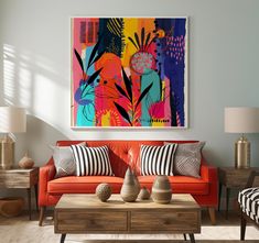 a living room scene with focus on the orange couch and colorful painting hanging over the coffee table