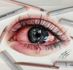 a drawing of an eye with long lashes and pink cheeks, surrounded by crayons